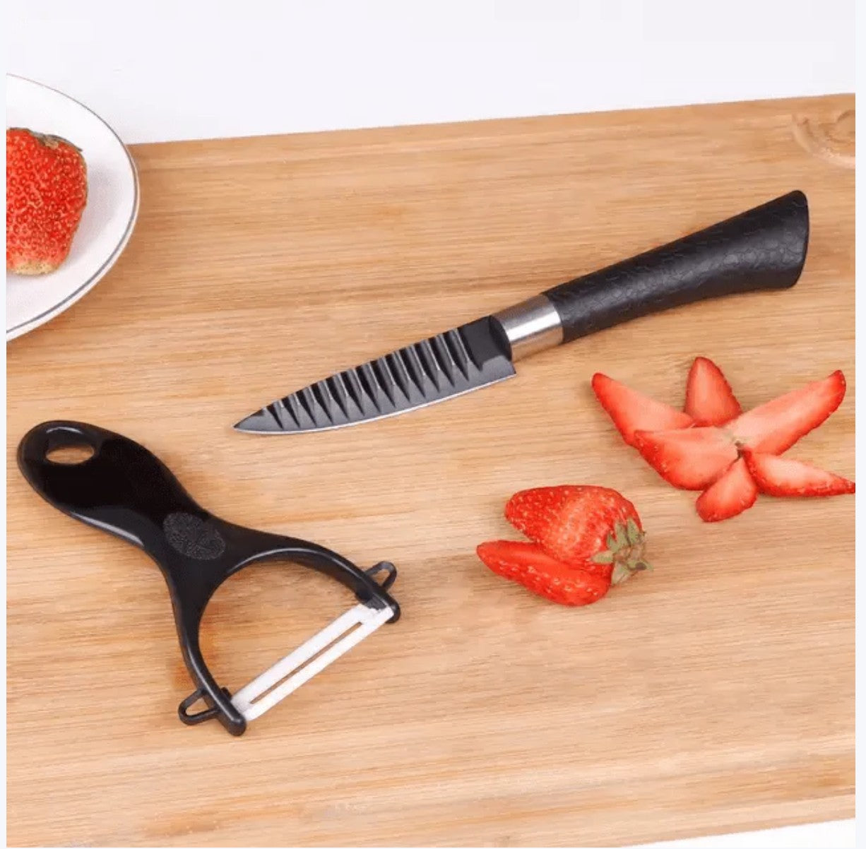 JHATPAT professional kitchen knife with serrated blade and ceramic peeler on a wooden cutting board with strawberries.